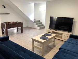 un soggiorno con divano, TV e tavolo di Apartament Telkom 1 a Milówka