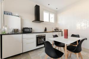 a kitchen with a table and chairs and a kitchen with white cabinets at Entre mer et campagne in Saint-Martin-de-Seignanx