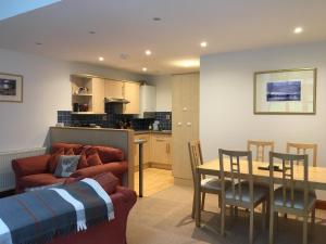 a living room and kitchen with a couch and a table at Lairds and Keepers Apartments in Dunkeld