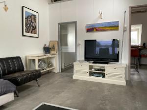 a living room with a television on a white entertainment center at Cosy appartment in Alkmaar