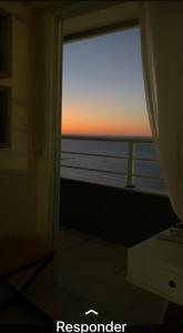 a view of the ocean from a window with a sunset at Apartamento Iracema Fortaleza in Fortaleza