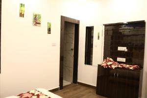 Habitación con cama, espejo y puerta en Madpackers Khajuraho en Khajurāho