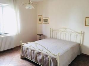 a bedroom with a white bed in a room at La Vecchia Lanterna da Ines...... in Romagnano al Monte
