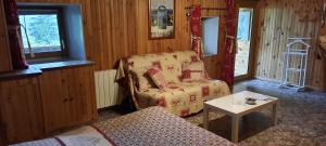 ein Wohnzimmer mit einer Couch, einem Sessel und einem Tisch in der Unterkunft L'Epicéa in Saint-Jean-dʼArves