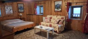 ein Schlafzimmer mit einem Bett, einer Couch und einem Tisch in der Unterkunft L'Epicéa in Saint-Jean-dʼArves