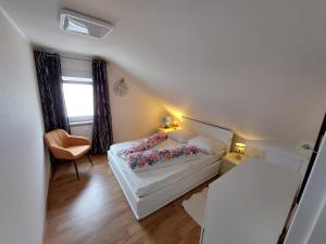 1 dormitorio pequeño con 1 cama y 1 silla en Ferienwohnung Krämer en Bönnigheim