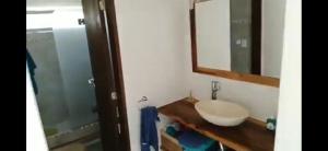 Un baño con lavabo, espejo y ducha. en Balcón del Bosque, en Monte Hermoso 6 fotos más