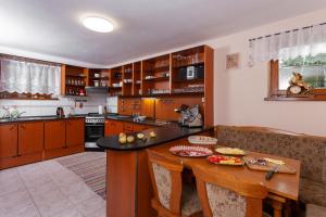 uma cozinha com uma mesa de madeira e uma bancada em Penzión Javor em Ždiar
