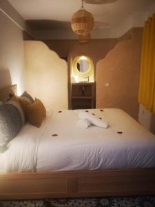 a bedroom with a large white bed with a mirror at LES EMBRUNS D'ESSAOUIRA - MAISON Privée in Essaouira +18 photos