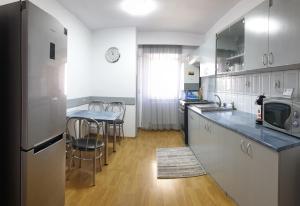 Vio apartament في زالاو: مطبخ مع طاولة وكراسي وقمة كونتر
