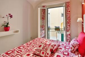 a bedroom with a red and white bed and a window at Apartments Amalfi Design in Amalfi