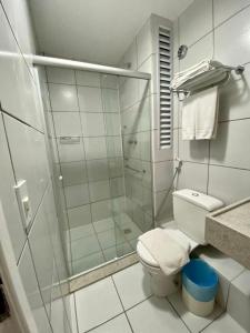 uma casa de banho branca com um chuveiro e um WC. em Gran Lençois Flat Residence - Barrerinhas (Aptº Particular) em Barreirinhas