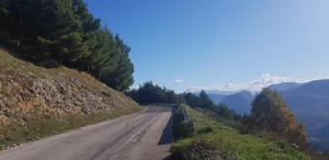 a dirt road on a hill with trees and mountains at La Vecchia Lanterna da Ines...... in Romagnano al Monte