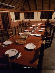 a long wooden table with plates and bowls on it at Lituba Lodge 