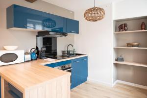 a kitchen with blue cabinets and a counter top at PERLEZENN VONTROULEZ (T2 45m2) in Morlaix