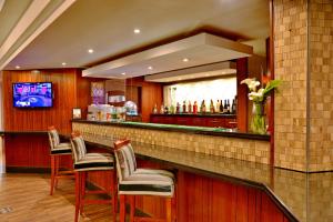 un bar en un hotel con sillas y espejo en City Lodge Hotel Bloemfontein en Bloemfontein