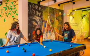 瑞詩凱詩的住宿－goSTOPS Rishikesh, Lakshman Jhula，三个女孩在一个带台球桌的房间打台球