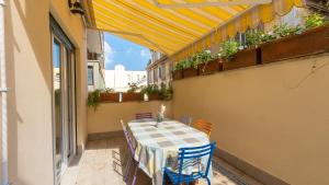 uma mesa e cadeiras numa varanda com um dossel amarelo em Rental in Rome - Annietta em Roma