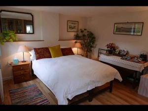 1 dormitorio con 1 cama blanca grande y escritorio en The Potting Shed, self contained, detached retreat in Shapwick village, en Shapwick
