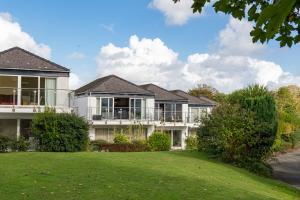 a house with a lawn in front of it at 25 Coedrath Park - Sea Views from Balcony, Short Walk to Beach, Parking in Saundersfoot