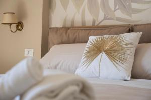 Una cama con una almohada con una palmera. en Oasi Smart Rooms en Caltanissetta