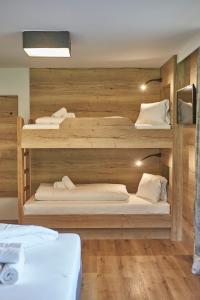 ザールバッハ・ヒンターグレムにあるAppartements Gappmaierの木製の壁の客室で、二段ベッド2組が備わります。