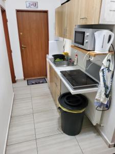 a small kitchen with a trash can and a microwave at London 3 call in Bratislava