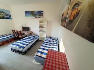 a room with two beds and a desk and a table at Smile 4 you in Bratislava