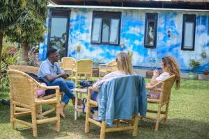 een groep mensen die in stoelen in een tuin zitten bij Acacia Villa Kampala in Kampala