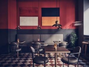 restauracja ze stołami, krzesłami i czerwonymi ścianami w obiekcie Hotel Flora w Göteborgu