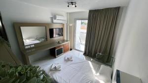 a hotel room with a bed and a television at Fotoxenia Luxury Apts in Paralimni