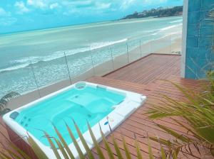 a hot tub on a deck next to the beach at Luxo e pé na areia in Parnamirim