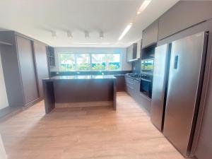 a large kitchen with a large island in the middle at Luxo e pé na areia in Parnamirim