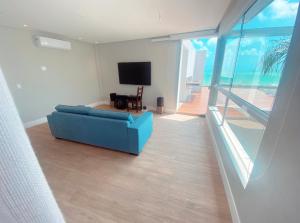 a living room with a blue couch and a television at Luxo e pé na areia in Parnamirim