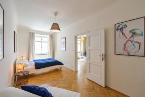 een slaapkamer met 2 bedden en een hal met een deur bij Celetná 27 Residence in Praag