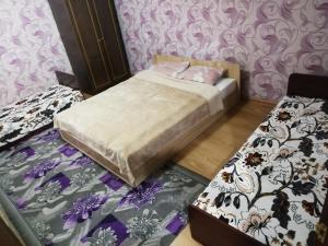 two beds in a room with purple and white wallpaper at Затишні Апартаменти in Umanʼ