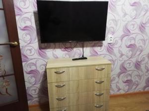 a flat screen tv on top of a dresser at Затишні Апартаменти in Umanʼ