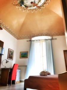1 dormitorio con cama, lámpara de araña y ventana en Palazzo Salìa, en Lecce