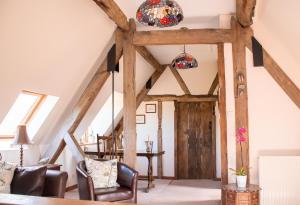 a room with wooden beams and chairs in a house at The Manor House, Broadway in Broadway