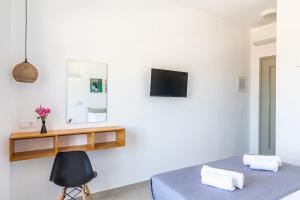 una camera con letto e TV a parete di Uncle John's Guesthouse a Skopelos Town