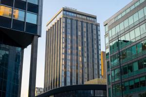 
a large building with a tall building behind it at Innside by Melia Liverpool in Liverpool
