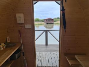 a door to a room with a view of a dock at Lakeside Fishing Pods in Boston