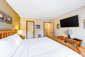 a bedroom with a large bed and a flat screen tv at Sunrise 8 in Mammoth Lakes