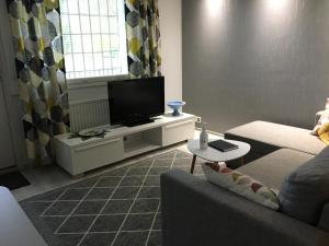 a living room with a couch and a flat screen tv at MajoitusMattila in Ylivieska