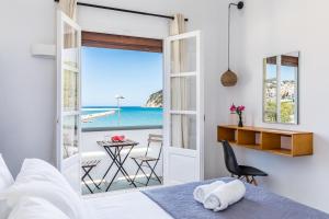 a bedroom with a bed and a view of the ocean at Uncle John's Guesthouse in Skopelos Town