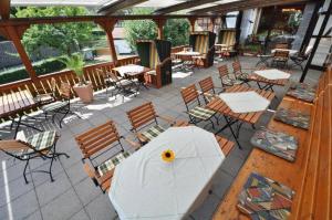 a patio with tables and chairs and a white table and chairs at Hotel Zum Stern in Rauischholzhausen