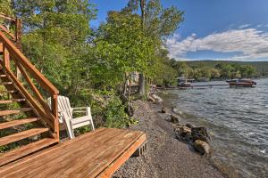 Aunt Als Place with Private Deck and Fire Pit! في Rushville: كرسي أبيض جالس على مرسى بجانب نهر