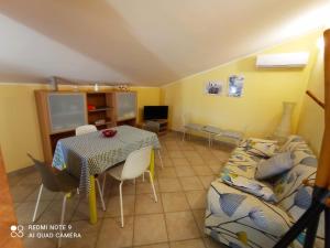 - un salon avec une table et un canapé dans l'établissement B&B Villa Maria Paola - Alloggi Temporanei Isernia, à Isernia