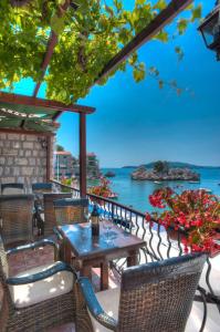 a table and chairs on a patio overlooking the water at Apartments Porat in Sveti Stefan