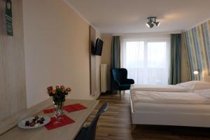 una habitación de hotel con una cama y una mesa con flores en Zum Weissen Lamm, en Rothenberg